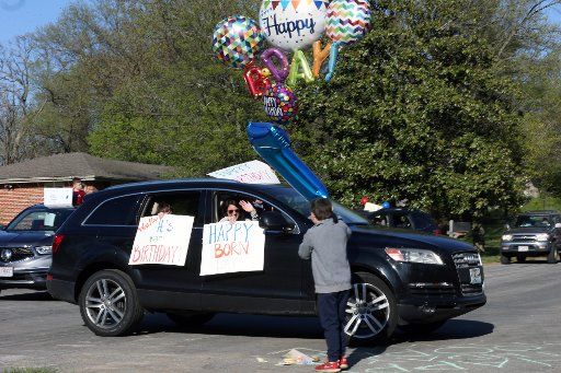 The new normal for celebrating birthday parties, guests pass by seven year-old Cooper Newman\