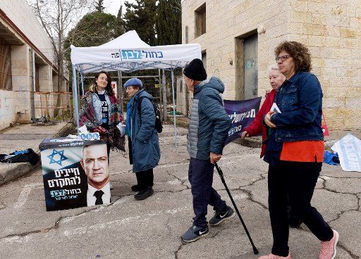 Israelis pass a campaign site for Benny Gantz outside a polling station in Jerusalem, on Monday, March 2, 2020. Israelis are voting in the third election in less than a year. Photo by Debbie Hill\/