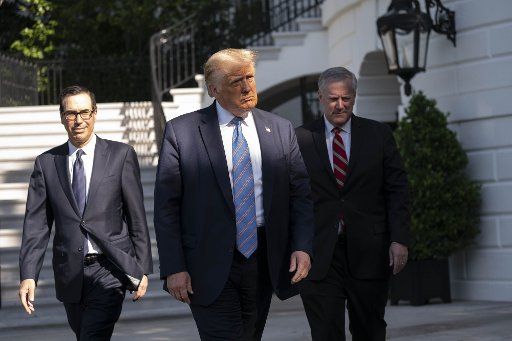 U.S. President Donald Trump, Secretary of the Treasury Steven Mnuchin and White House Chief of Staff Mark Meadows walk to address the press on the South Lawn of the White House in Washington, D.C., U.S., on Wednesday, July 29, 2020. Photo by Sarah Silbiger
