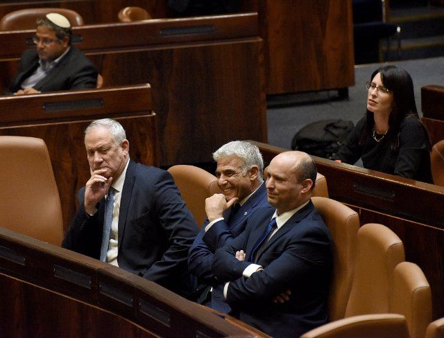 Prime Minister Naftali Bennett (R) sits with Foreign Minister Yair Lapid (C) and Defense Minister Benny Gantz (L) in the new Unity Government in the Israeli Knesset, the Parliament, in Jerusalem, on Sunday, June 13, 2021. Israeli Prime Minister Benjamin Netanyahu ends his twelve year reign as prime minister. Photo by Debbie Hill