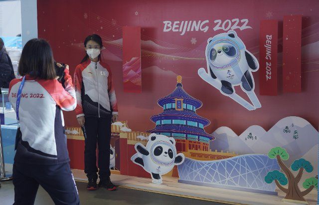 Workers pose for a photo with the Beijing Olympic mascot at the Main Media Center for the Winter Olympics in Beijing on February 1, 2022. The opening ceremony for the games is February 4, 2022. Photo by Rick T. Wilking