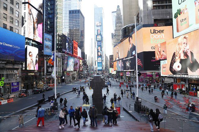 Pedestrians walk in Times Square on Tuesday, February 8, 2022 in New York City. Photo by John Angelillo