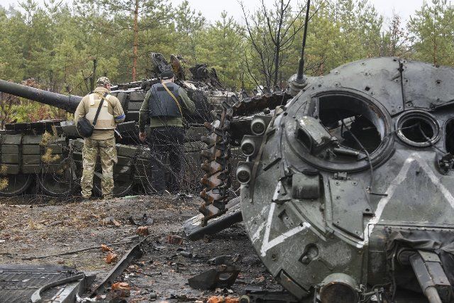 Ukrainian soldiers inspect a destroyed Russian tank amid Russia\