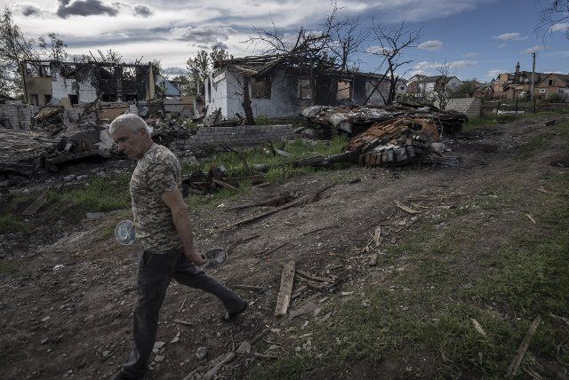 A man walks by a Russian tank destroyed by Ukrainian Forces in Vilhivka, Ukraine, Friday, May 13, 2022. Russian soldier Vadim Shishimarin was arrested and charged by prosecutors for the civilian\