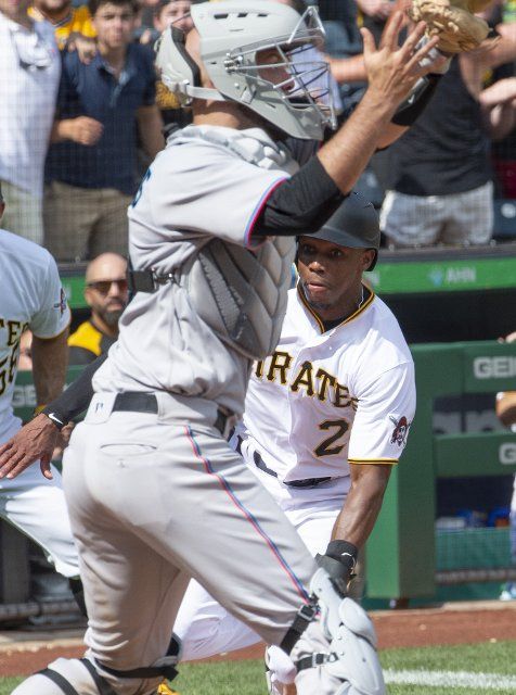 Miami Marlins catcher Jacob Stallings (58) waits for the throw as Pittsburgh Pirates left fielder Greg Allen (24) slides safel into home to tie the score in the ninth inning at PNC Park on Sunday July 24, 2022 in Pittsburgh. Photo by Archie Carpenter