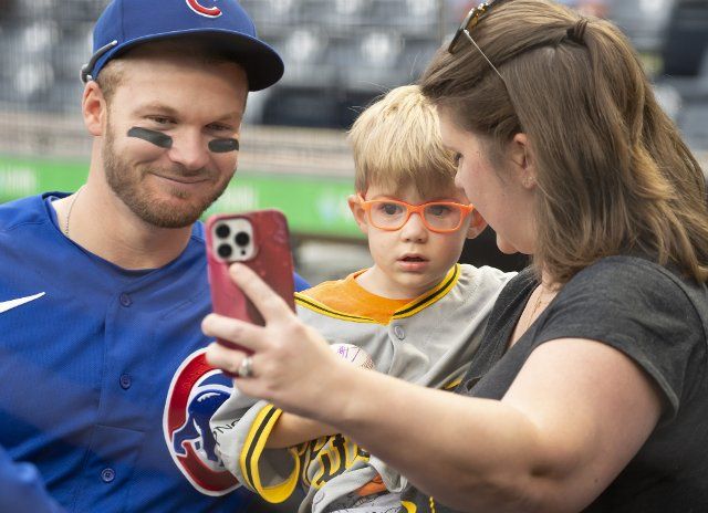Chicago Cubs left fielder Ian Happ (8) poses for a photo with a young fan following the 8-5 win against the Pittsburgh Pirates at PNC Park on Sunday September 25, 2022 in Pittsburgh. Photo by Archie Carpenter