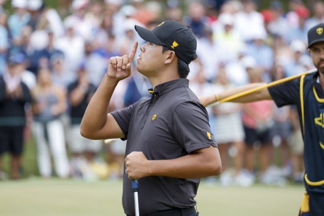 Si Woo Kim, of South Korea, tries to quiet the crowd after winning the hole on the 15th hole as the United States wins the Presidents Cup golf championship in Charlotte, North Carolina on Sunday, September 25, 2022. Photo by Nell Redmond