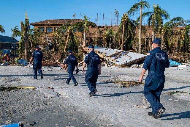 U.S. Coast Guard (USCG) personnel assigned to the Gulf, Atlantic, and Pacific Strike teams walk among debris to scan for unaccounted people in Fort Myers Beach, Florida, on September 29, 2022. Coast Guard National Strike Force teams mobilized to areas affected by Hurricane Ian to perform urban search and rescue operations. Photo by POC3 Gabriel Wisdom\/U.S.Coast Guard