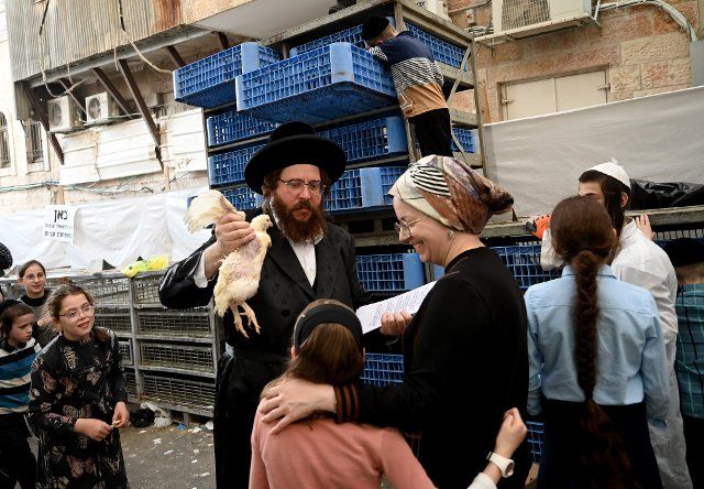 An Ultra-Orthodox Jewish man holds a chicken to perform the Kapparot ritual in Mea Shearim in Jerusalem on Monday, October, 3, 2022. The Kapparot ritual is conducted before Yom Kippur, the Day of Atonement, the holiest day in the Jewish calendar that starts at sundown on October 4. Photo by Debbie Hill