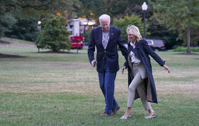 President Joe Biden takes the arm of First Lady Dr. Jill Biden on wet grass as they return to the White House after visiting Fort Myers, Florida on Wednesday, October 5, 2022. The President and First Lady will surveyed storm-ravaged areas and received a briefing on current response and recovery efforts. Photo by Leigh Vogel