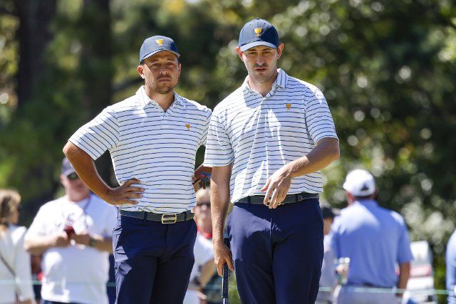 Xander Schauffele, left, talks with Patrick Cantlay as they study a putt on the third hole for the USA team during Four-Ball match play at the Presidents Cup golf championship in Charlotte, North Carolina on Friday, September 23, 2022. Photo by Nell Redmond