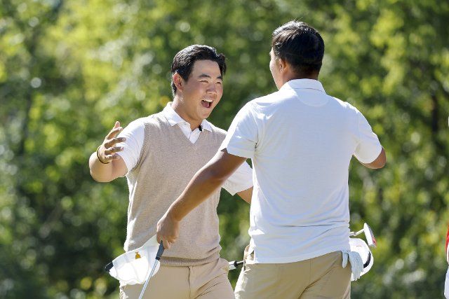 Tom Kim, of South Korea, left, hugs K.H. Lee, of South Korea, after they won their foursomes match at the Presidents Cup golf championship in Charlotte, North Carolina on Saturday, September 24, 2022. Photo by Nell Redmond