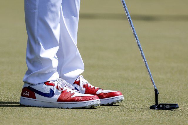 Tony Finau wears patriotic shoes as he prepares to putt during his four-ball match at the Presidents Cup golf championship in Charlotte, North Carolina on Saturday, September 24, 2022. Photo by Nell Redmond