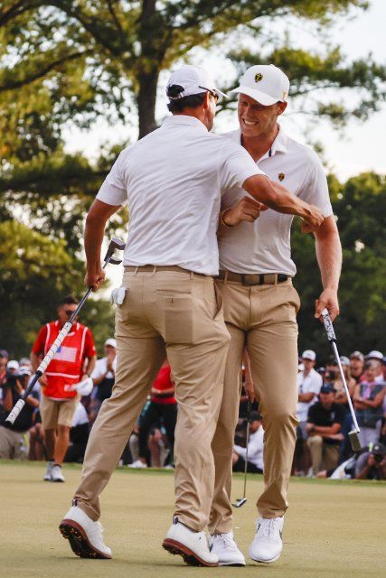 Adam Scott, of Australia, left, and Cam Davis, of Australia, celebrate winning a point for the International team at the Presidents Cup golf championship in Charlotte, North Carolina on Saturday, September 24, 2022. Photo by Nell Redmond
