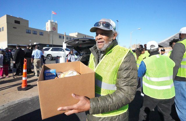 Former St. Louis Football Cardinals and National Football Hall of Fame member Johnny Roland, carries a box of food supplies to a waiting car during the Thanksgiving food give-a-way at the Urban League of Greater St. Louis in St. Louis on Tuesday, November 22, 2022. Roland joined several other former NFL football players that live in the area, to pass out over 2500 Thanksgiving turkeys and all of the fixings to those in need. Photo by Bill Greenblatt