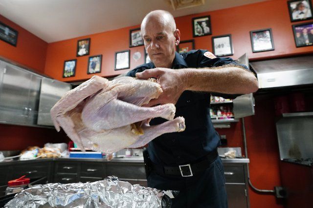 St. Louis firefighter Kevin Keller prepares a Thanksgiving Day turkey for the oven at Engine House 2 that will be served for Thanksgiving dinner on Thursday, November 24, 2022. The 25 pound turkey will serve eight firefighters who serve at the firehouse. Approximately 136 St. Louis firefighters at thirty two firehouses will be preparing Thanksgiving Day dinner as they work instead of being with their families. Photo by Bill Greenblatt