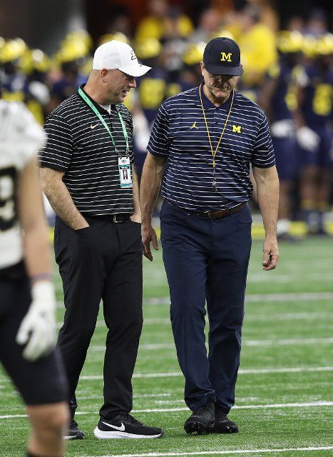 Michigan Wolverines head coach Jim Harbaugh (R) talks with Purdue Boilermakers head coach Jeff Brohm prior to the start of the Big Ten Championship game in Indianapolis, Indiana on Saturday, December 3, 2022. Photo by Aaron Josefczyk