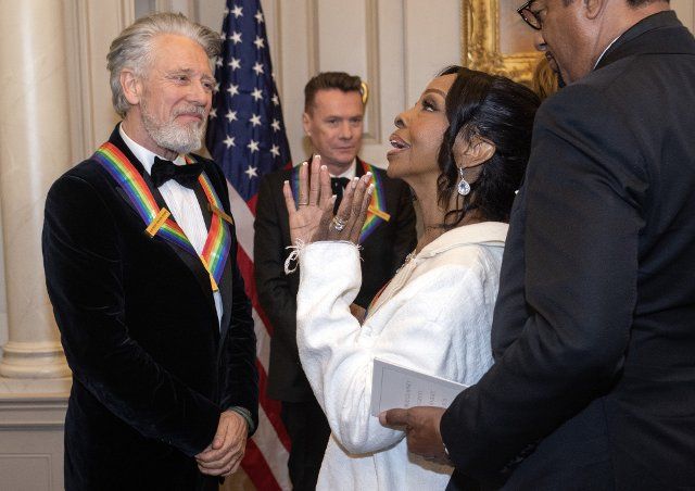 Adam Clayton, left and Gladys Knight, right, two if the recipients of the 45th Annual Kennedy Center Honors converse after posing for a group photo following the Artists Dinner at the US Department of State in Washington, DC on Saturday, December 3, 2022. The 2022 honorees are: actor and filmmaker George Clooney contemporary Christian and pop singer-songwriter Amy Grant legendary singer of soul, Gospel, R&B, and pop Gladys Knight Cuban-born American composer, conductor, and educator Tania LeÃ³n and iconic Irish rock band U2, comprised of band members Bono, The Edge, Adam Clayton, and Larry Mullen Jr. Photo by Ron Sachs