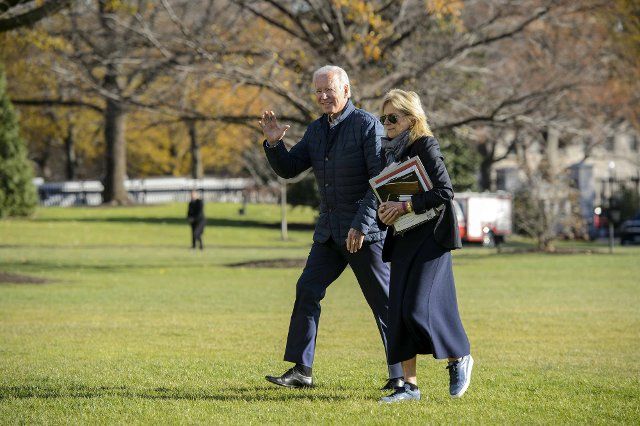 President Joe Biden and First Lady Jill Biden walk across the South Lawn after exiting Marine One at the White House in Washington, DC on Sunday, December 4, 2022. The Biden\