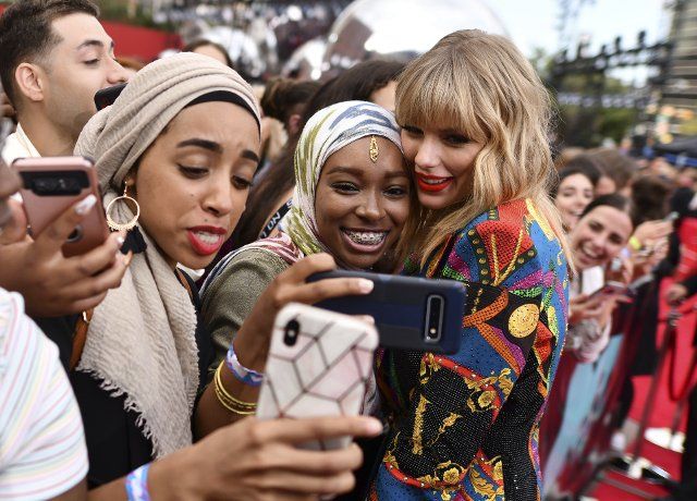 Taylor Swift, right, takes selfies with fans as she arrives at the MTV Video Music Awards at the Prudential Center on Monday, Aug. 26, 2019, in Newark, N.J. (Photo by Charles Sykes\/Invision\/AP
