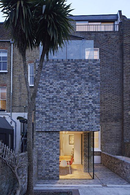 Dusk view of double-height rear extension with corner window on ground level. Queens House, London, United Kingdom. Architect: Paul Archer Design - Architects & Design, 2021