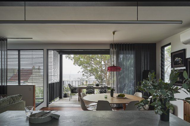 Dining area and outdoor terrace looking from kitchen. Birchgrove House, Sydney, Australia. Architect: TW Architects, 2021