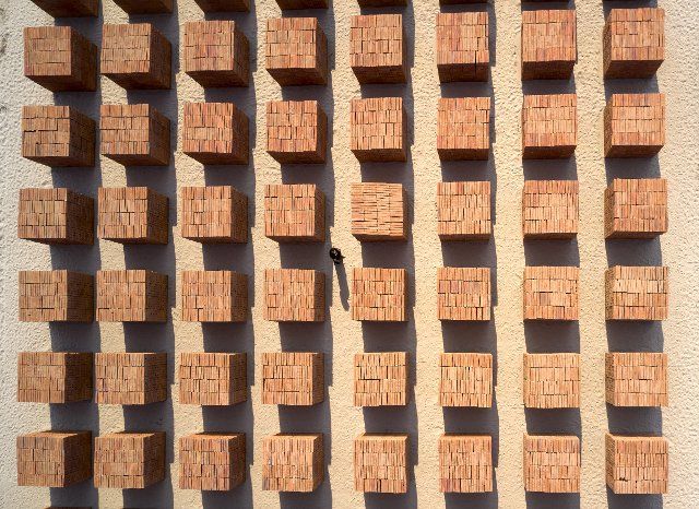Ariel view of brick sculpture with solitary figure. Atlantes Pavillion at Casa Wabi 2022, Puerto Esondido, Mexico. Architect: Tadao Ando, 2022