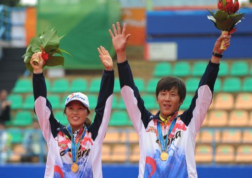 (101115) -- GUANGZHOU Nov. 15 2010 (Xinhua) -- Ji Yong Min(R)\/ Kim Kyung Ryun of South Korea gold medalists wave to audience on the podium during the awarding ceremony for the mixed doubles event of Soft Tennis at the 16th Asian Games in ...