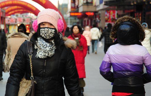 (110115) -- SHENYANG Jan. 15 2011 (Xinhua) -- Residents in heavy coat walk in a street in Shenyang capital of northeast China\