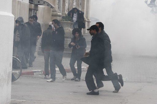 (110118) --TUNIS Jan. 18 2011 (Xinhua) -- Protestors run away as police use tear gas during a demonstration against Tunisia\
