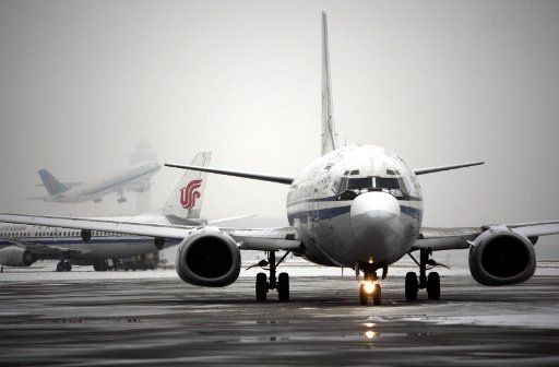 (110213) -- BEIJING Feb. 13 2011 (Xinhua) -- A plane waits to be removed of ice at Beijing Capital International Airport in Beijing capital of China Feb. 13 2011. Beijing embraced the second snowfall this winter since Saturday night. (Xinhua\/...