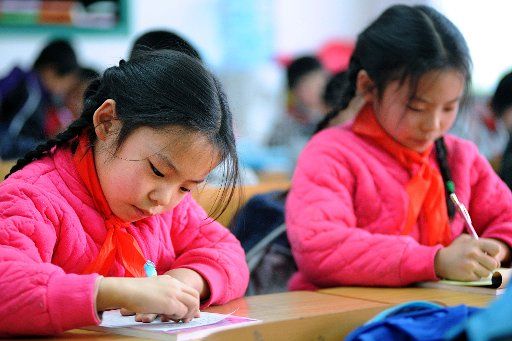 (110301) -- SHENYANG March 1 2011 (Xinhua) -- A pair of twin girls have the first class of the new semester at Shashanjie Fourth Primary School a primary school for children of migrant workers in Shenyang capital of northeast China\