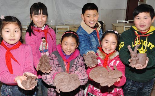 (110308) -- SUZHOU March 8 2011 (Xinhua) -- Pupils show pottery works they make as gifts for their mothers during an event held to mark Inthernational Women\