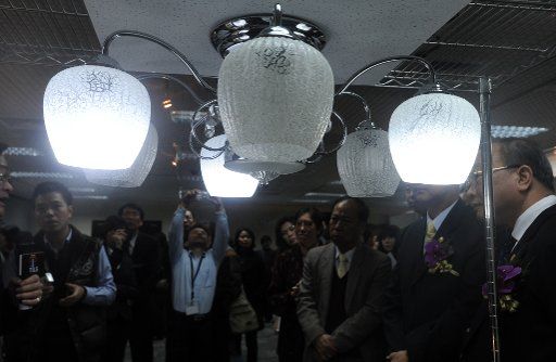 (110310) -- TAIPEI March 10 2011 (Xinhua) -- Visitors look at a set of ceiling lamp which is able to illuminate for two hours when it is powered off at an international lighting show in Taipei southeast China\