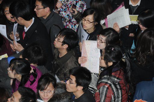 (110323) -- CHANGCHUN March 23 2011 (Xinhua) -- Job seekers look at information during a recruitment fair organized by five noted universities in Changchun capital of northeast China\