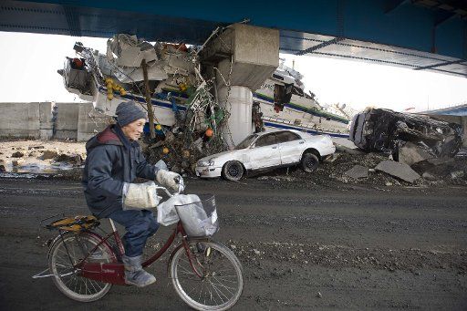 (110313) -- MIYAKO March 13 2011 (Xinhua) -- A resident rides passing ruins in Miyako of Iwate Japan March 13 2011. The earthquake and the ensuing tsunami hit the city of Miyako on Friday leaving 41 people dead 11 people injured and 628 ...