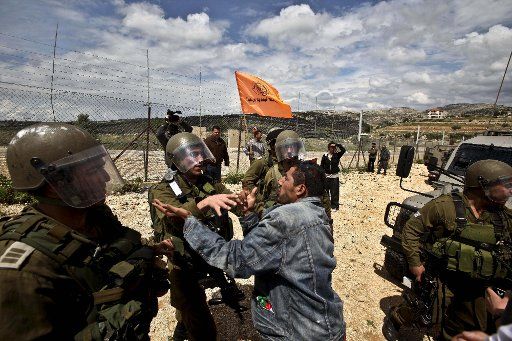 (110422) -- WEST BANK April 22 2011 (Xinhua) -- A Palestinian protester argues with Israeli soldiers during a weekly protest against the controversial Israeli barrier in the West Bank village of Bilin near Ramallah on April 22 2011. (Xinhua\/...
