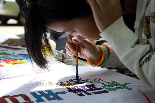 (110423) -- BEIJING April 23 2011 (Xinhua) -- A student paints on a T-shirt during a campus carnival at Tsinghua University in Beijing capital of China April 23 2011 one day ahead of Tsinghua University\