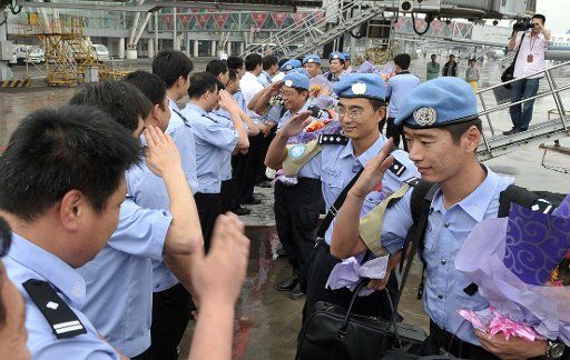 (110520) -- JINAN May 20 2011 (Xinhua) -- Policemen of Shandong Public Security Bureau welcome the peacekeeping policemen who just returned from foreign missions at the Jinan International Airport in Jinan capital of east China\