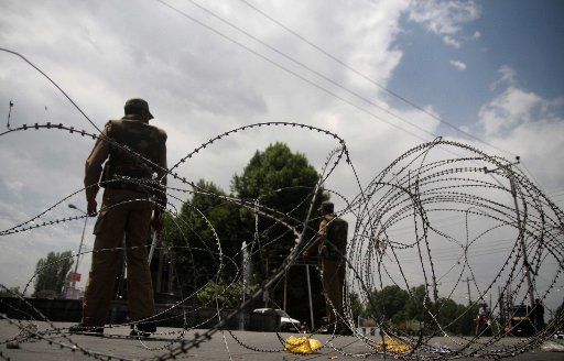 (110521) -- SRINAGAR May 21 2011 (Xinhua) -- Indian policemen stand guard near barbed wire in Srinagar the summer capital of Indian-controlled Kashmir on May 21 2011. Authorities in restive Kashmir placed separatist leaders under house arrest on ...