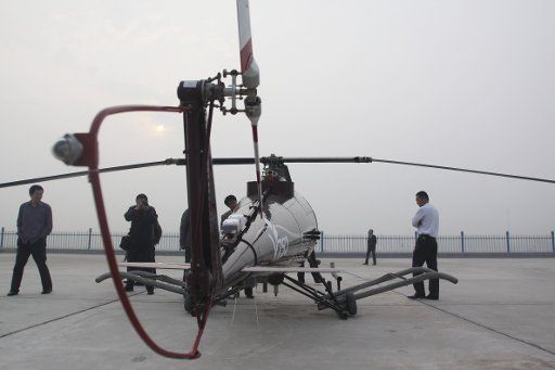 (110507) -- WEIFANG May 7 2011 (Xinhua) -- People look at the "V750" pilotless helicopter during a test flight in Weifang of east China\