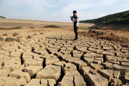 (110601) -- HANGZHOU June 1 2011 (Xinhua) -- A cameraman shoots the cracks in a dried-up reservoir in Changxing County Huzhou City east China\
