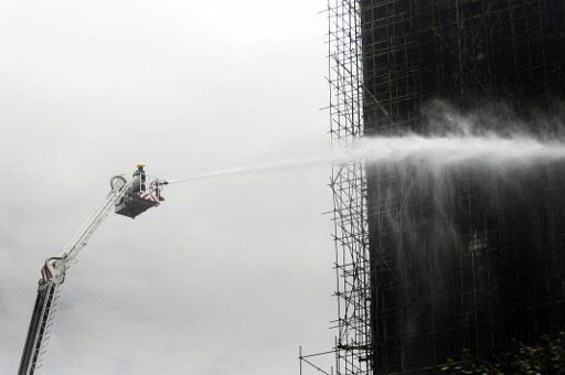 (110727) -- YINCHUAN July 27 2011 (Xinhua) -- A fire fighter sprays water to extinguish fire at a construction site near the crossroad of Beijing Road and Lijing Street in Yinchuan capital of northwest China\