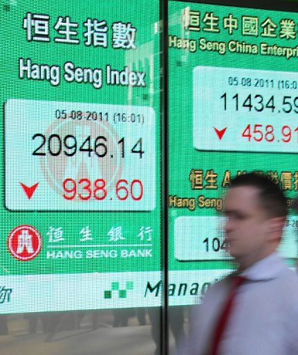 (110805) -- HONG KONG Aug. 5 2011 (Xinhua) -- A pedestrian walks past an electronic screen showing the Hang Seng Index in Hong Kong south China Aug. 5 2011. The Hang Seng Index shed 938.60 points or 4.29 percent to close at 20946.14 on Friday....