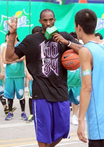 (110721) -- SHANGHAI July 21 2011 (Xinhua) -- Kobe Bryant demonstrates basketball skills to a young player in east China\