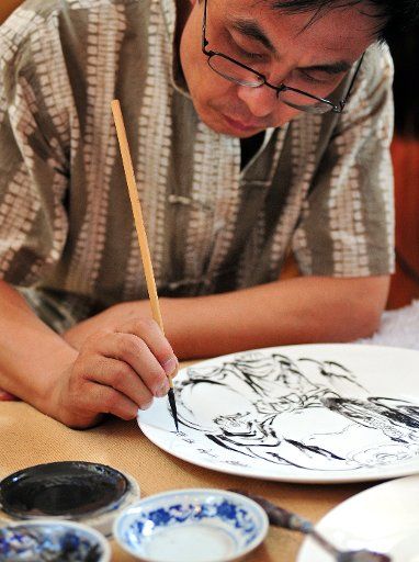 (110825) -- SHENYANG Aug. 25 2011 (Xinhua) -- A painter performs pottery painting at the opening ceremony of the fourth Culture Industry Fair of Northeast China in Shenyang northeast China\