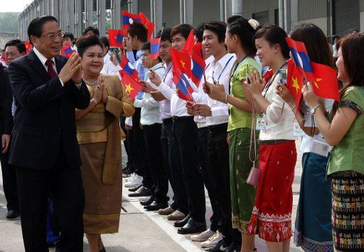 (110808) -- HANOI Aug. 8 2011 (Xinhua) -- Lao Party General Secretary and President Choummaly Sayasone (1st L) and his wife are greeted by Lao students in Vietnam upon arrival at the airport in Hanoi Vietnam Aug. 8 2011. Choummaly Sayasone is ...