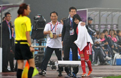 (110911) -- JINAN Sept. 11 2011 (Xinhua) -- Han Duan(R) of China is embraced by her coach Li Xiaopeng during the match against Japan at the Asian women\