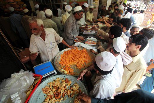 (110901) -- PESHAWAR Sept. 1 2011 (Xinhua) -- People gather at a shop to buy traditional sweets for their relatives and loved ones to celebrate the second day of Eid-al-Fitr festival in northwest Pakistan\