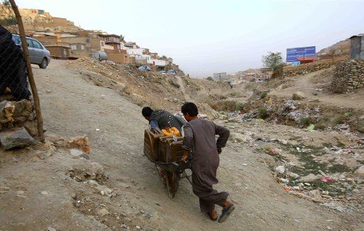(110929) -- KABUL Sept. 29 2011 (Xinhua) -- Two men carry water home near a public water pump in Kabul Afghanistan Sept. 25 2011. In Kabul 80 percent of the population live in unplanned settlements where poor sanitation and lack of access to ...